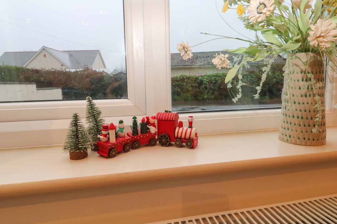 A decorative train and small trees on a windowsill at Ridgeback House in Mullion