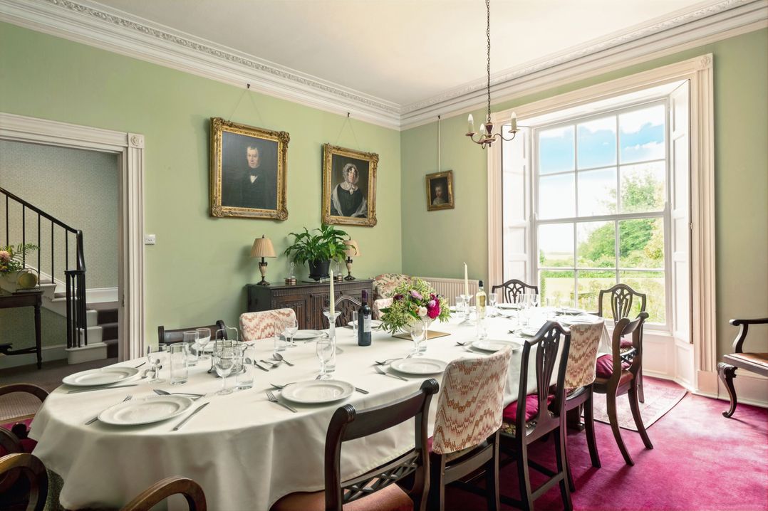 A dining room with a table set for a meal at Parnacott in Holsworthy