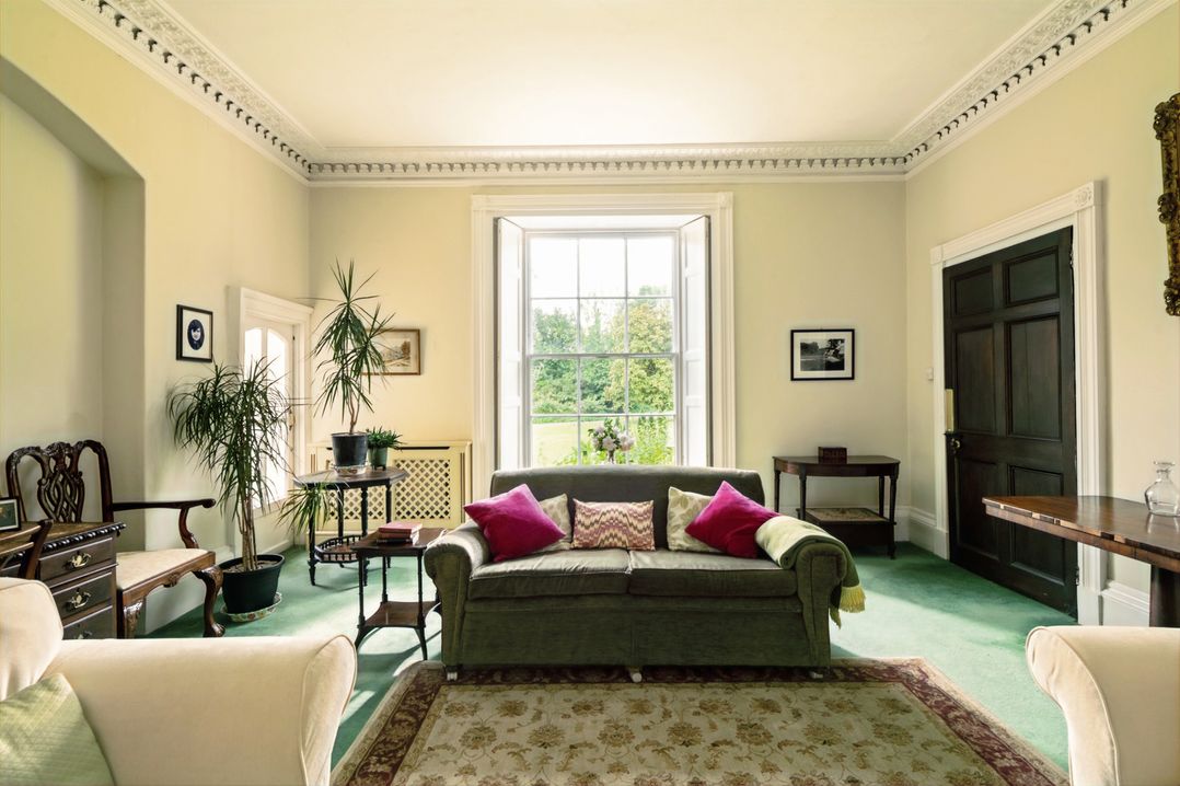 A living room featuring a sofa, table, and plants at Parnacott in Holsworthy