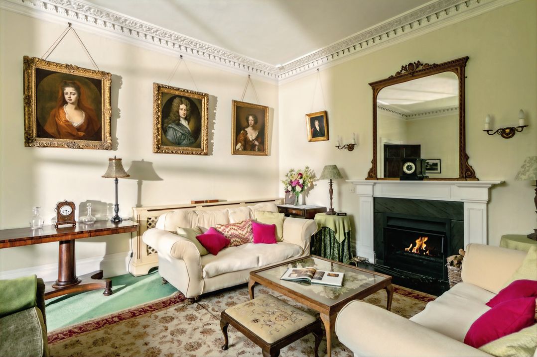 A living room with paintings and a fireplace at Parnacott in Holsworthy