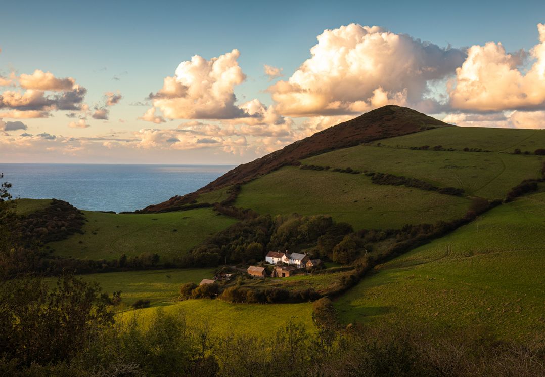 A house in a field with hills and ocean in the background at 3 Manleigh Park Combe Martin