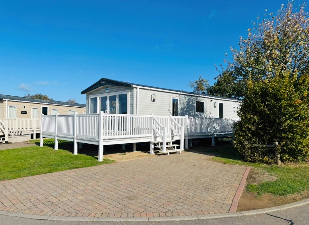 A mobile home with a deck and steps at Primrose Valley Park - Pebbles Retreat in Primrose Valley