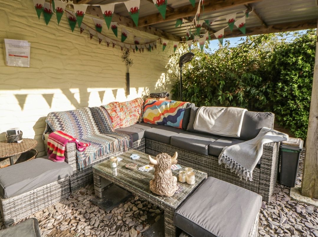 An outdoor seating area with a sofa and table at Yr Hen Llaethdy in Blaen-Cil-Llech near Newcastle Emlyn