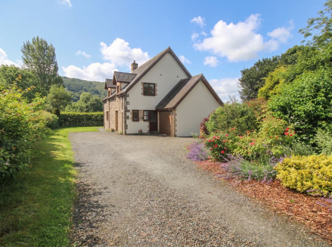 A house with a driveway and garden at Byne Brook Cottage in Strefford near Craven Arms