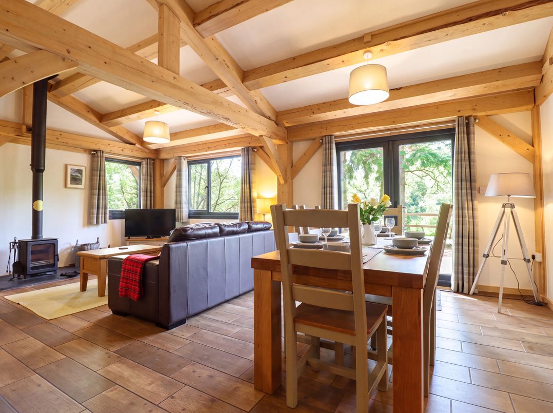 A living room with a sofa and dining table at Lady Bagots Cabin in Ruthin