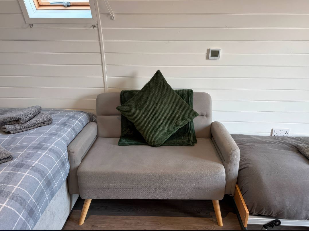 A bedroom with a sofa and bed at Natures Nest near Rillington