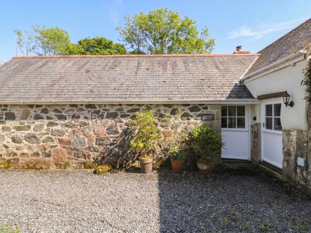 An outdoor area with stone wall and plants at Swallows, St Keverne, Lizard Peninsula