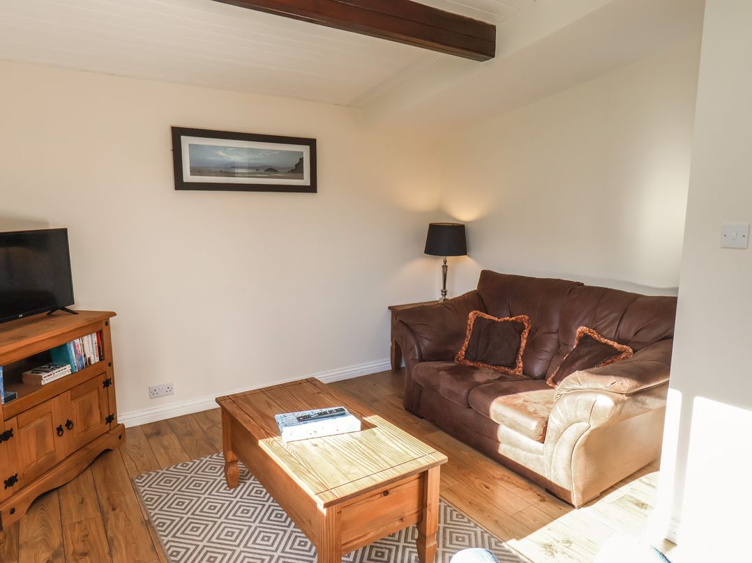 A living room with a sofa, coffee table, and television at Foxglove Lodge Saltburn-By-The-Sea