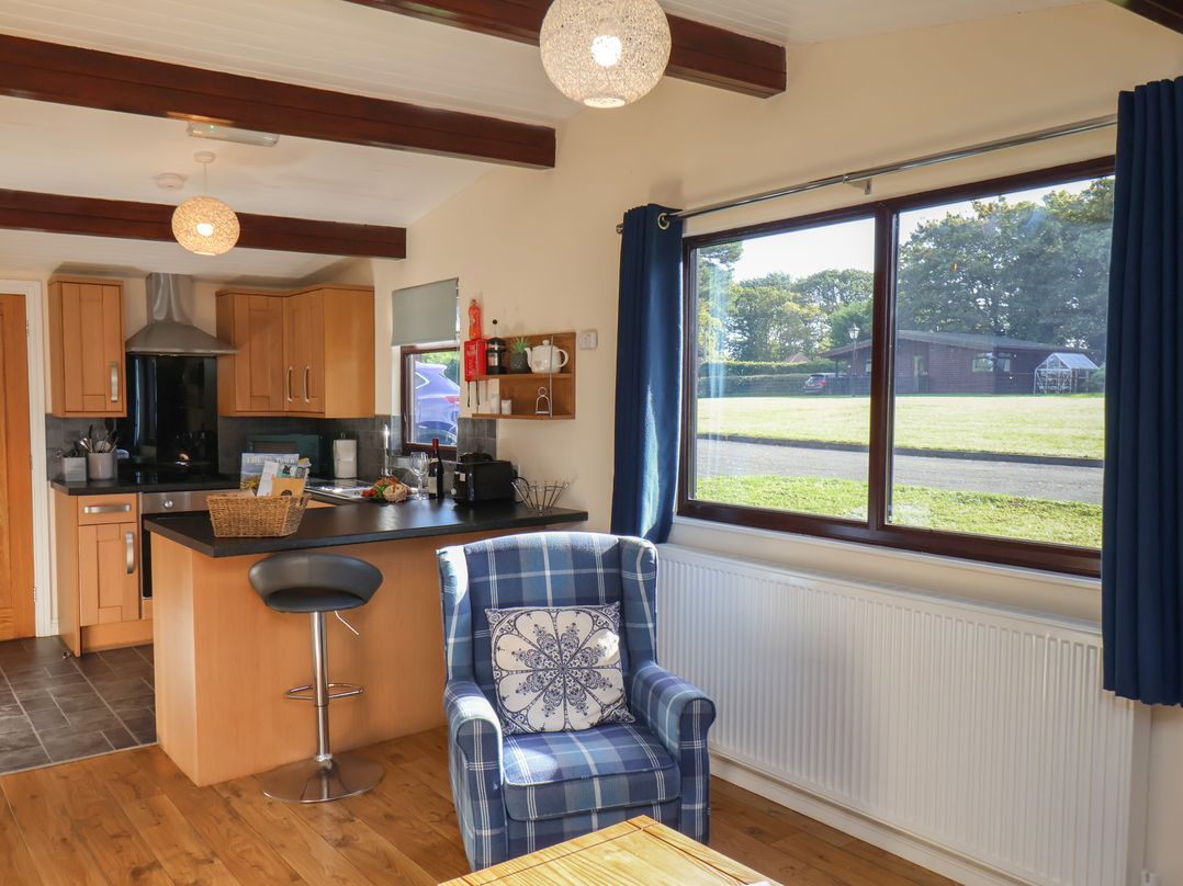 A kitchen with a stool and sofa at Foxglove Lodge in Saltburn-By-The-Sea