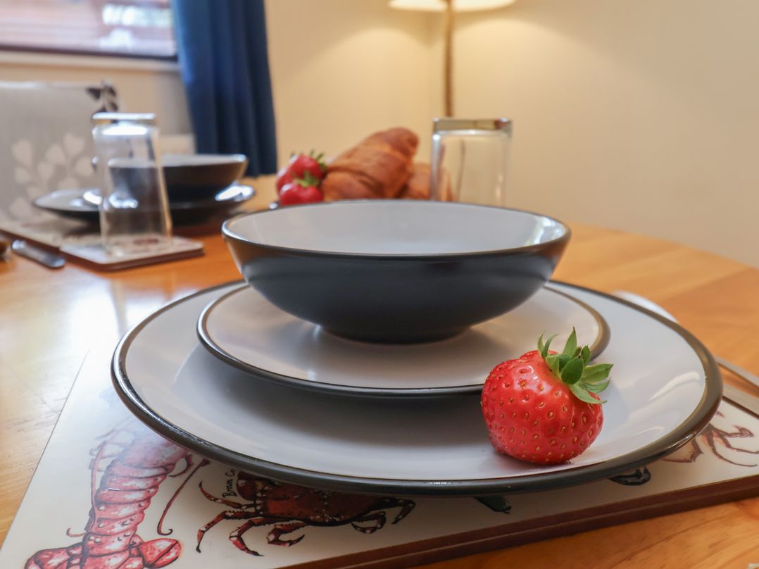 A table setting with bowls plates and strawberry at Foxglove Lodge Saltburn-By-The-Sea