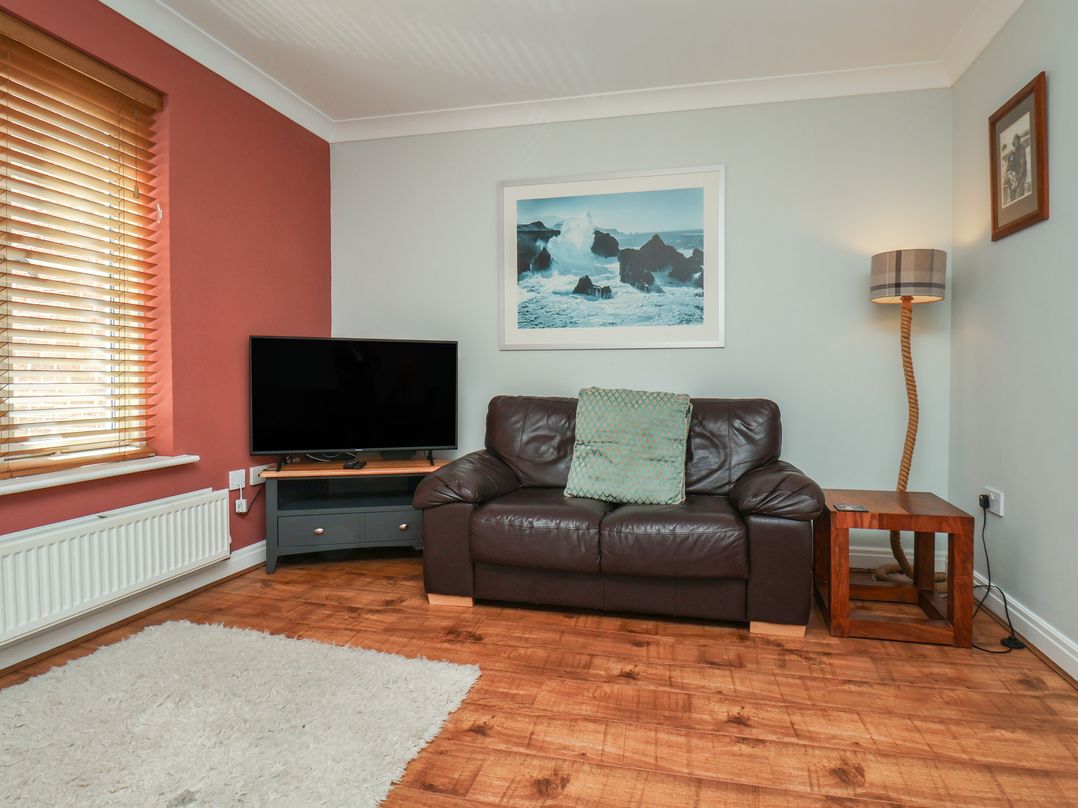 A living room with a TV and sofa at Tides Reach in Whitby