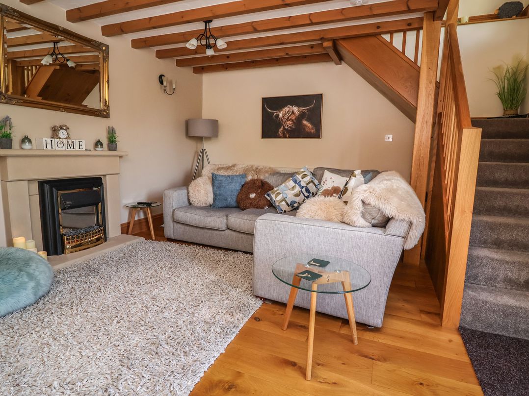A living room with a sofa and fireplace at Ash Farm Cottage Lixwm near Caerwys