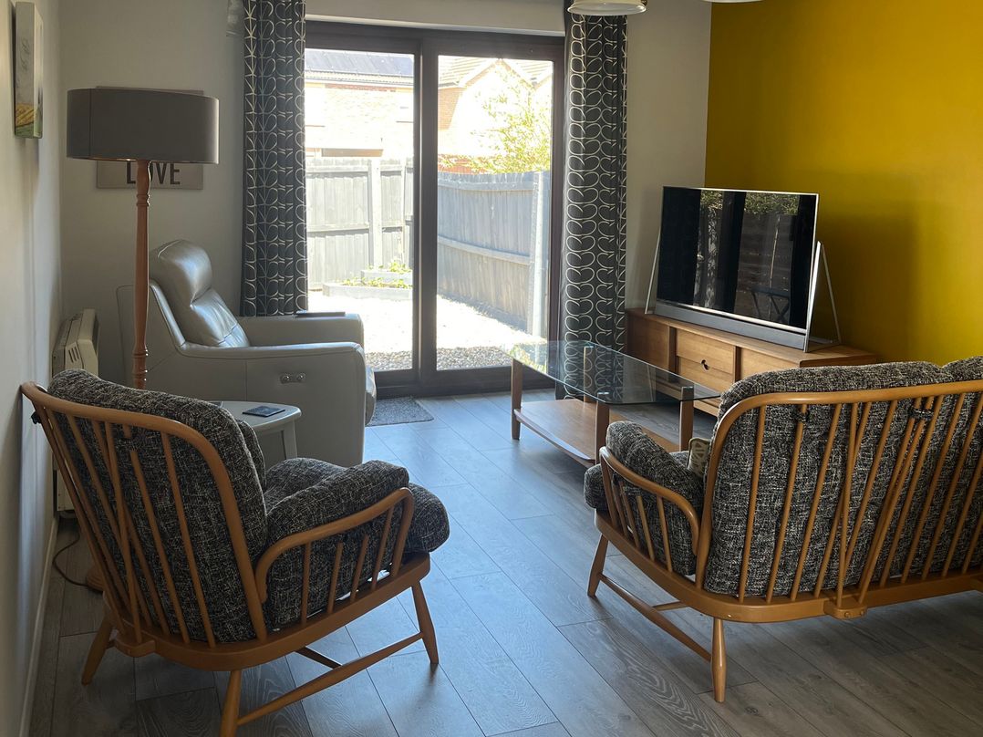 A living room with a television and seating at Village Retreat in Littleport