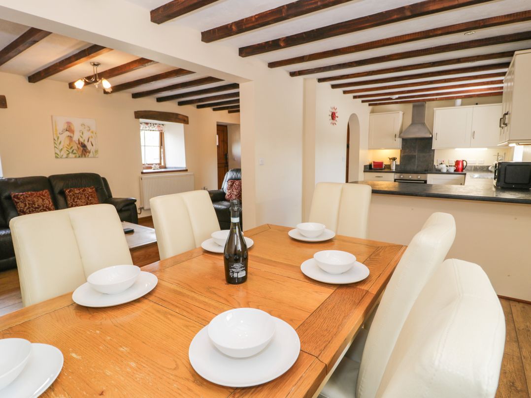 A dining room with a table and chairs at Stabal-y-Gwedd in Dolwen near Abergele