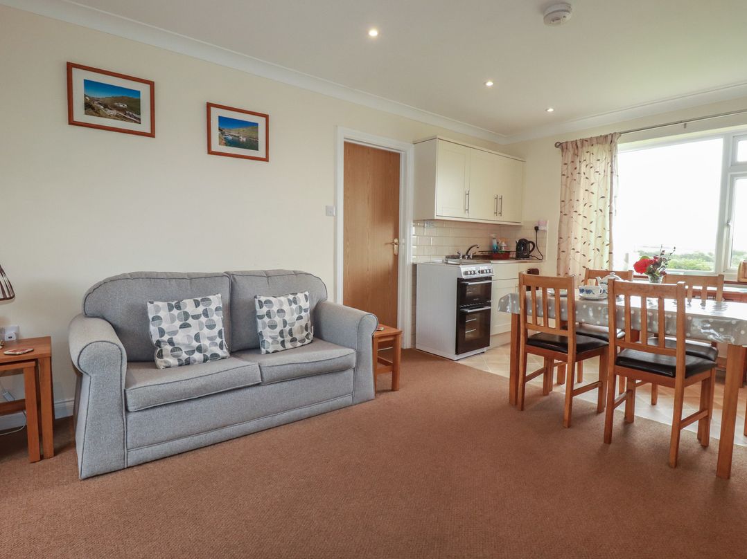 A living room with a sofa and dining area at Little Lanes in Boscastle