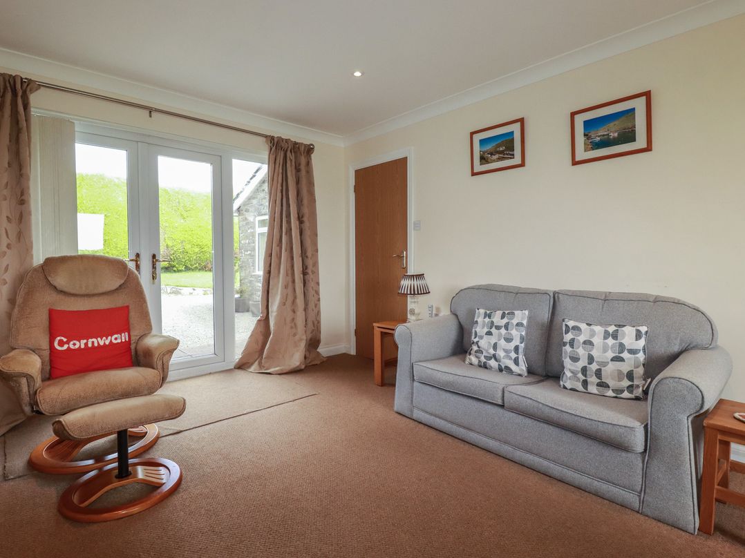 A living room with a sofa and armchair at Little Lanes in Boscastle