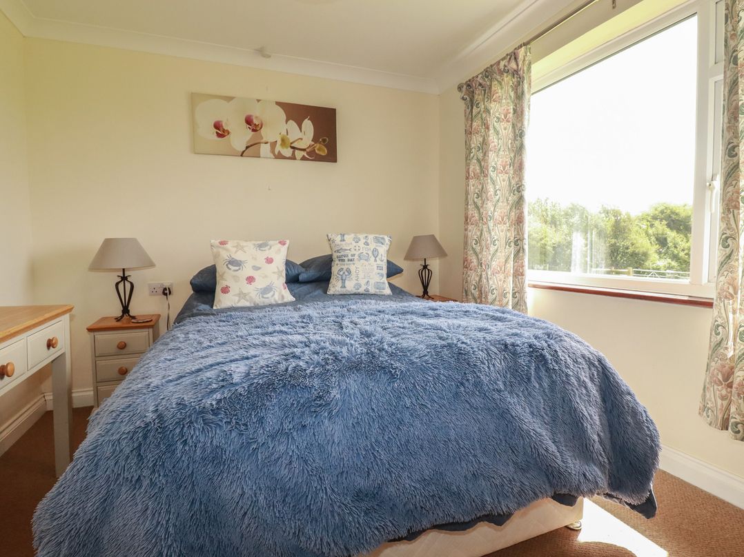 A bedroom with a bed and a window at Little Lanes in Boscastle