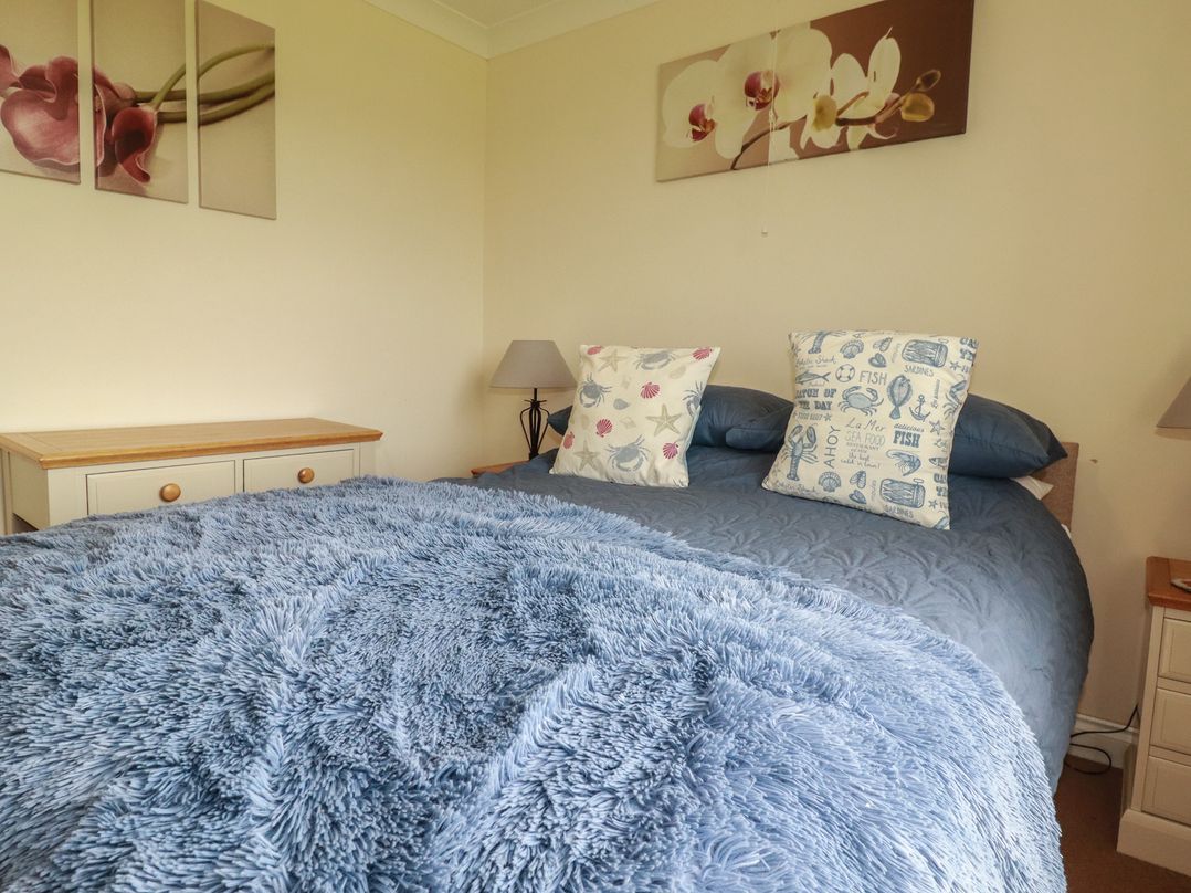 A bedroom with a bed and decorative pillows at Little Lanes in Boscastle