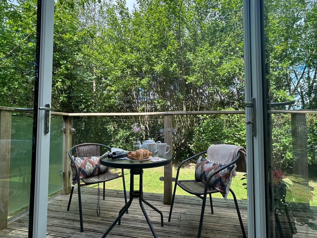 An outdoor seating area with a table and chairs at The Hideout in Lanreath