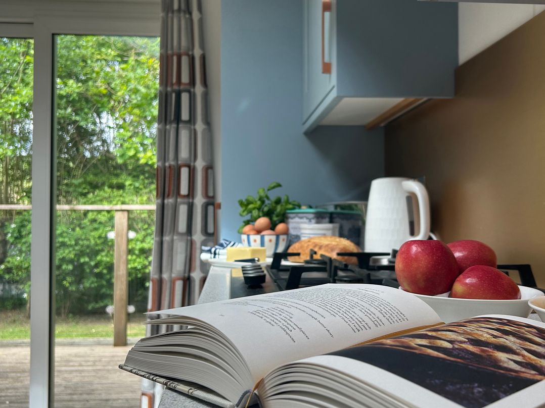 A kitchen with apples and a cookbook at The Hideout in Lanreath