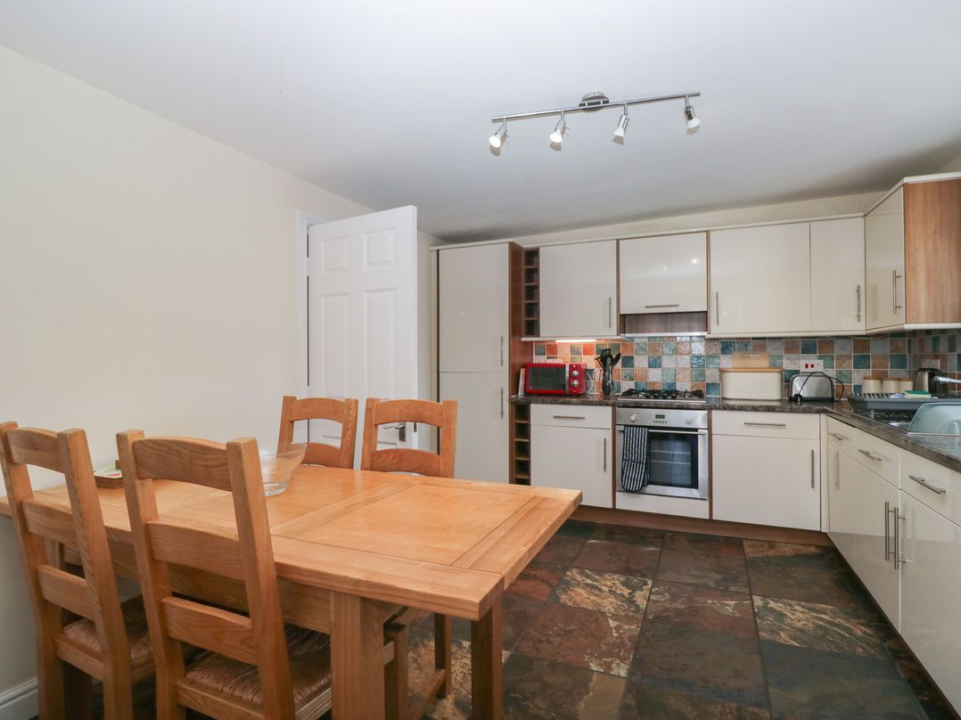 A kitchen with a dining table and chairs at Woodside West in Bowness