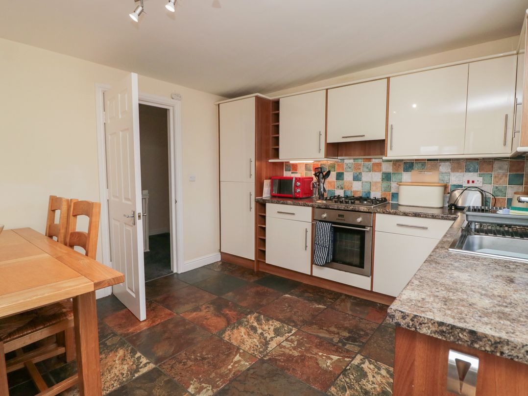 A kitchen with appliances and a dining table at Woodside West in Bowness