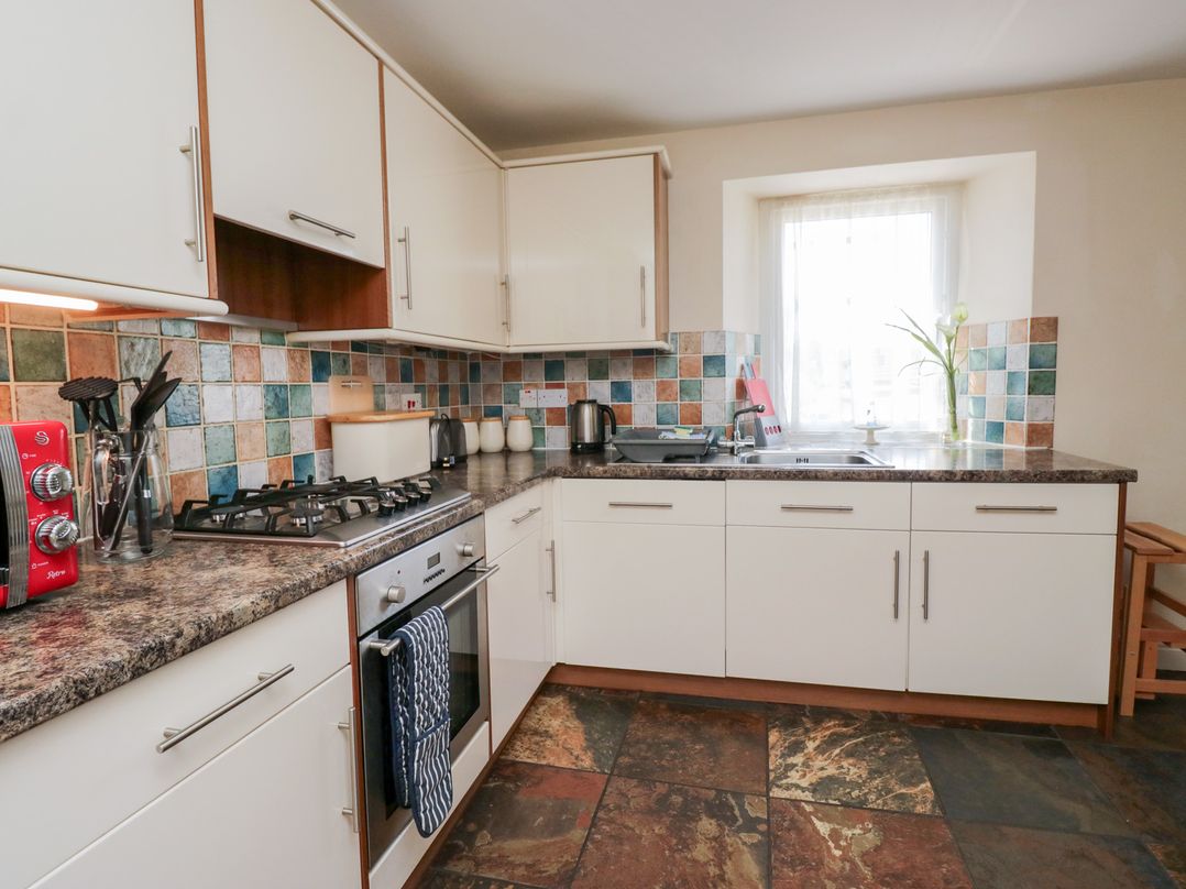 A kitchen with cabinets and a stove at Woodside West Bowness