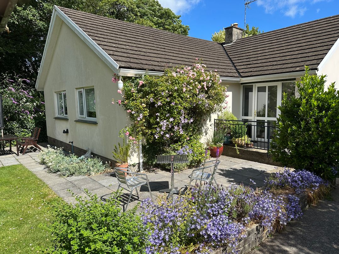 A garden with a house and seating area at Goldcrest in Newport, Pembrokeshire