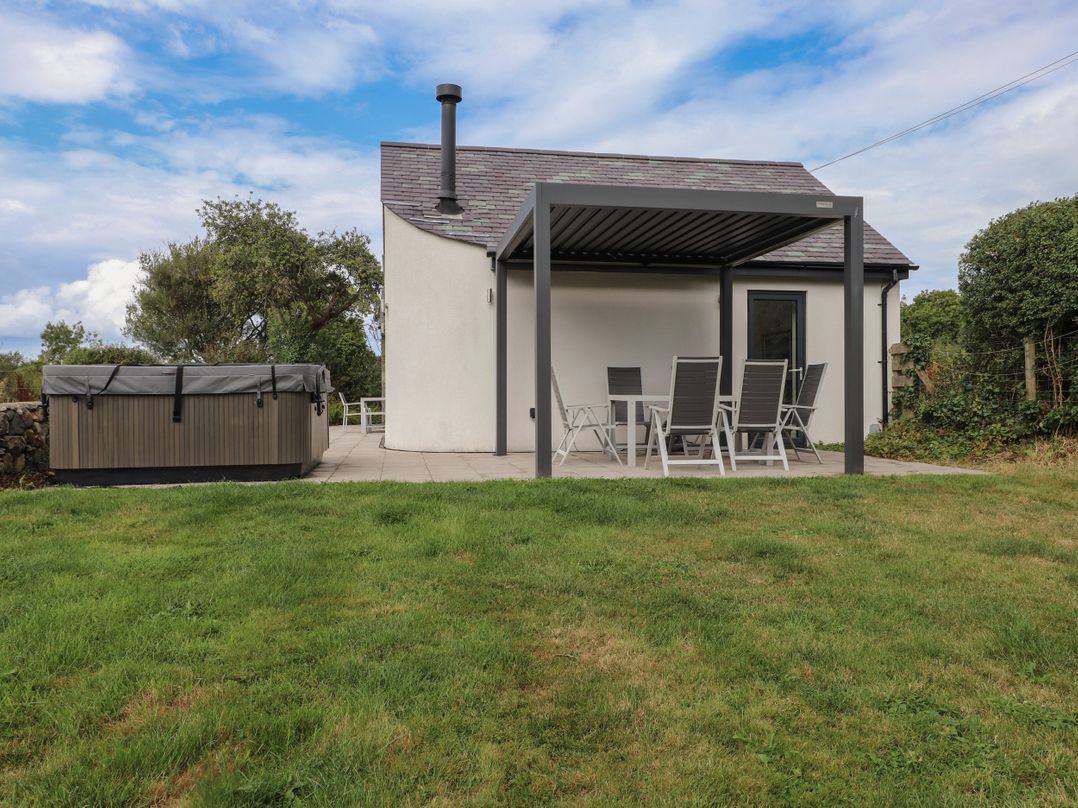 A patio area with a hot tub and seating at Pen Y Cefn in Pen Y Cefn