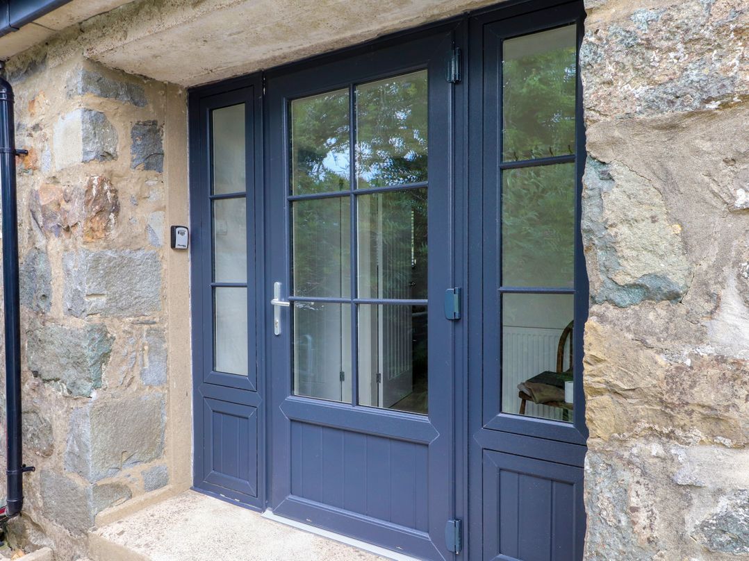 An entrance with double doors and a stone wall at Pen Y Cefn