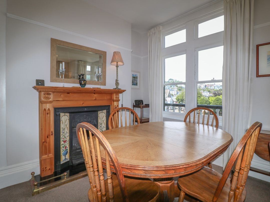 A dining room with a table and chairs at 2 York House in Dartmouth