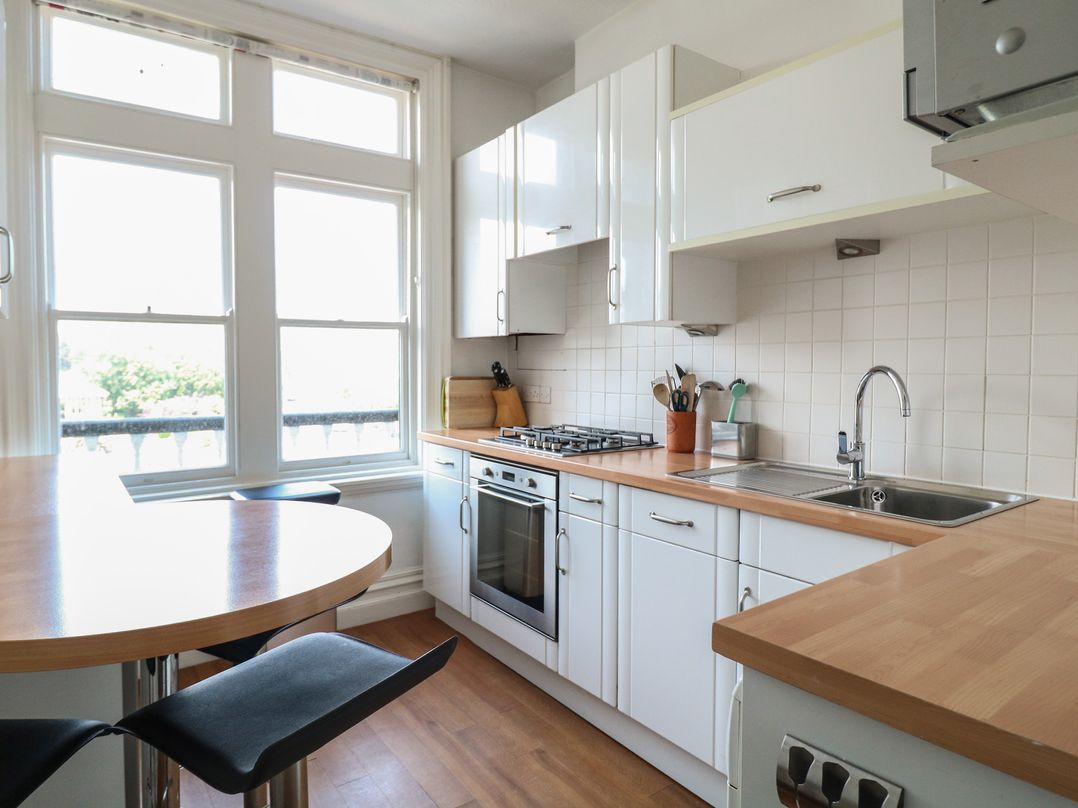 A kitchen with cabinets and a gas stove at 2 York House in Dartmouth
