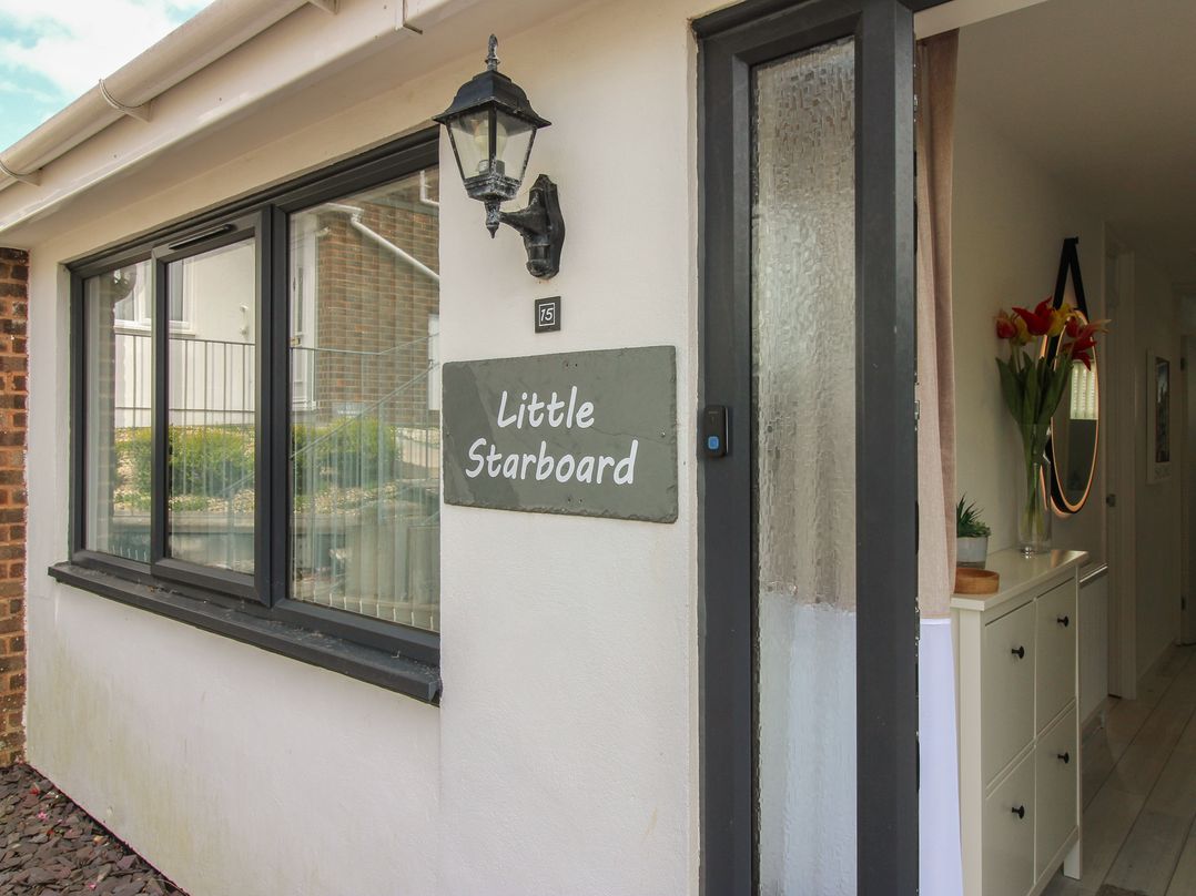 An entrance with a house sign and plants at Little Starboard in Kingsbridge