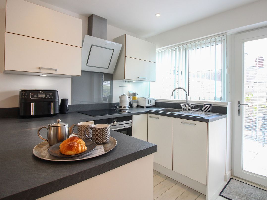 A kitchen with cabinets and a sink at Little Starboard in Kingsbridge