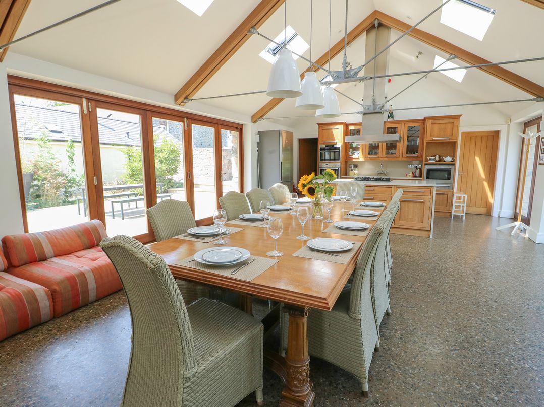 A kitchen with a dining table and chairs at Clynnog House in Dwyran near Newborough
