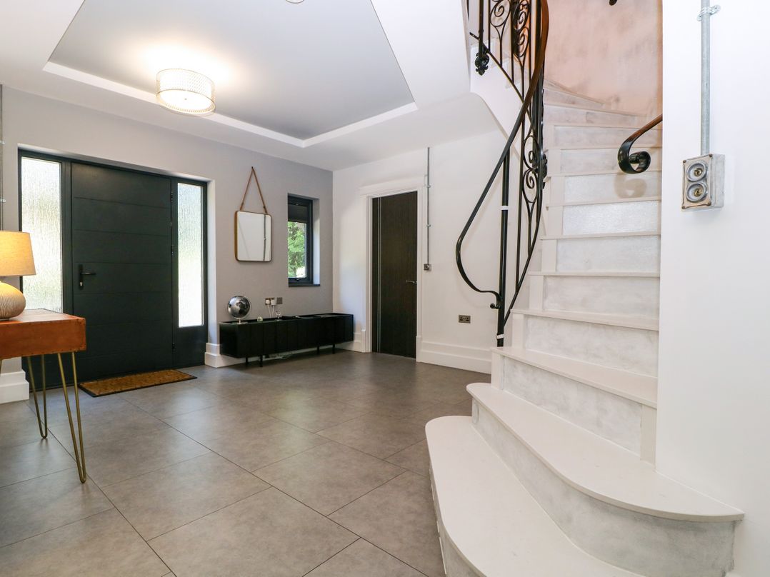 A hallway with a staircase and console table at Thornbury in Barnard's Green, Malvern