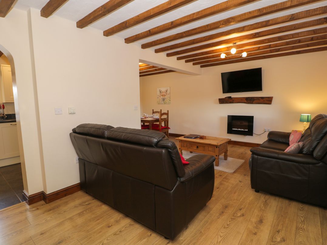A living room with a coffee table and sofa at Bwthyn Y Wennol Dolwen near Abergele