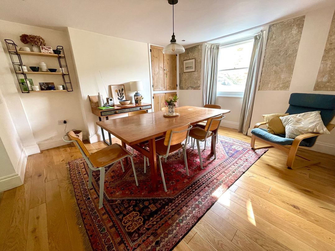 A dining room with a table and chairs at Widgeons Keel in Flushing