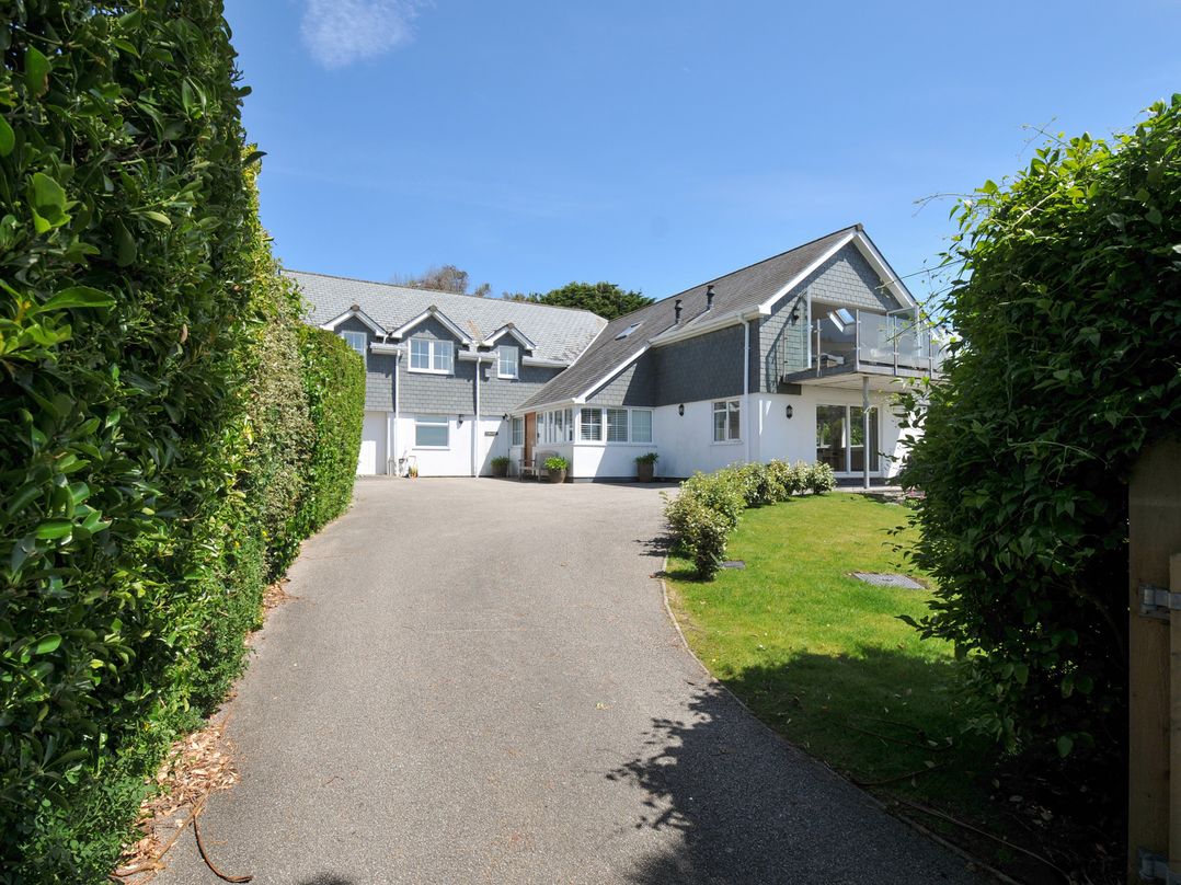 A house with a driveway and greenery at Farlands in Daymer Bay