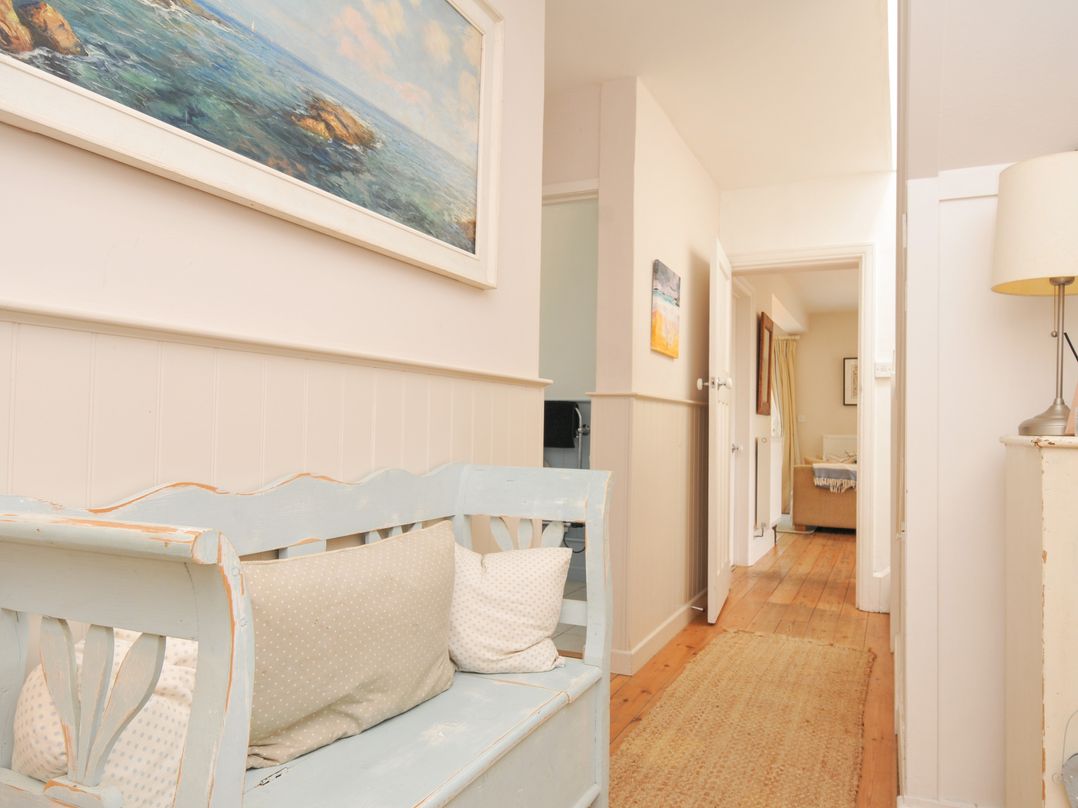 A hallway with a bench and a painting at Sandy Lodge Rock