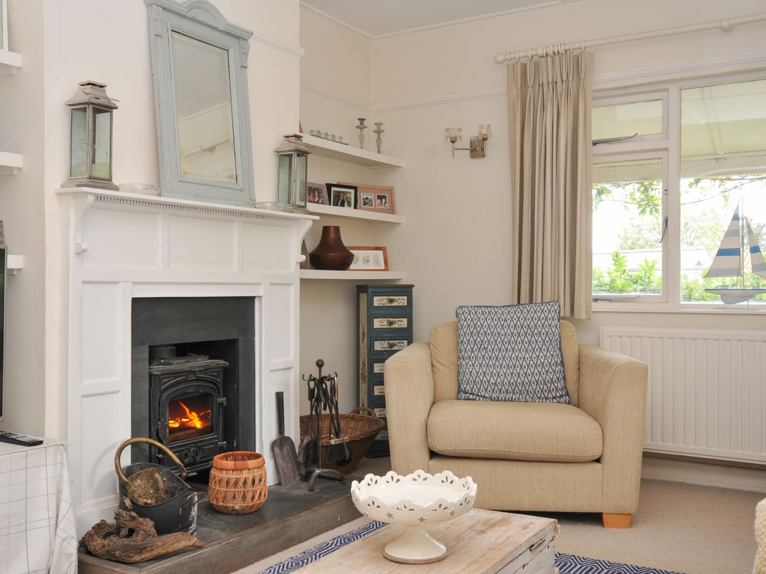 A living room with a fireplace and armchair at Sandy Lodge Rock