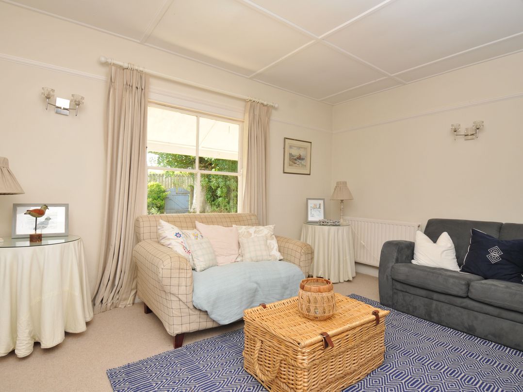 A living room with a sofa, armchair and coffee table at Sandy Lodge Rock