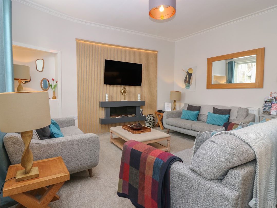 A living room with a television and sofa at 2 Abbey Row Kelso
