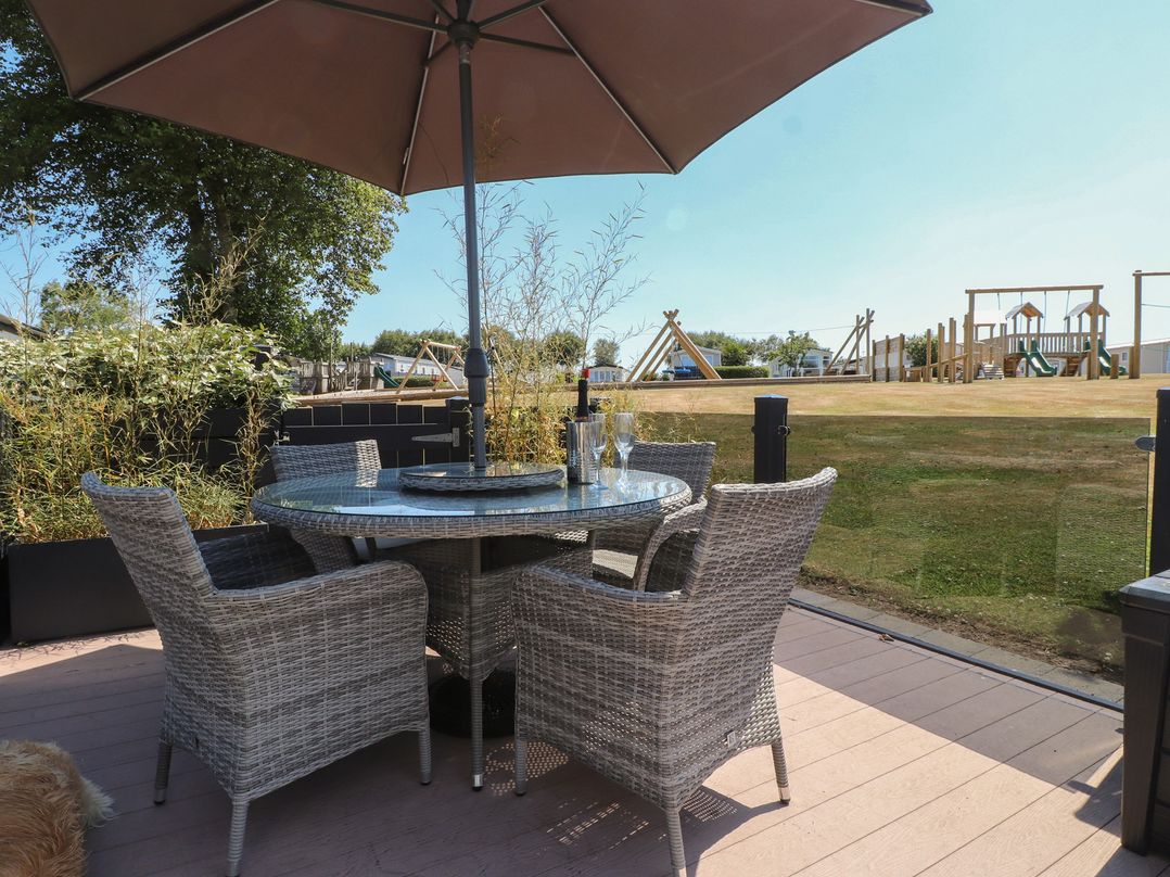 An outdoor area with a table and chairs under an umbrella at 97 Crugan Llanbedrog