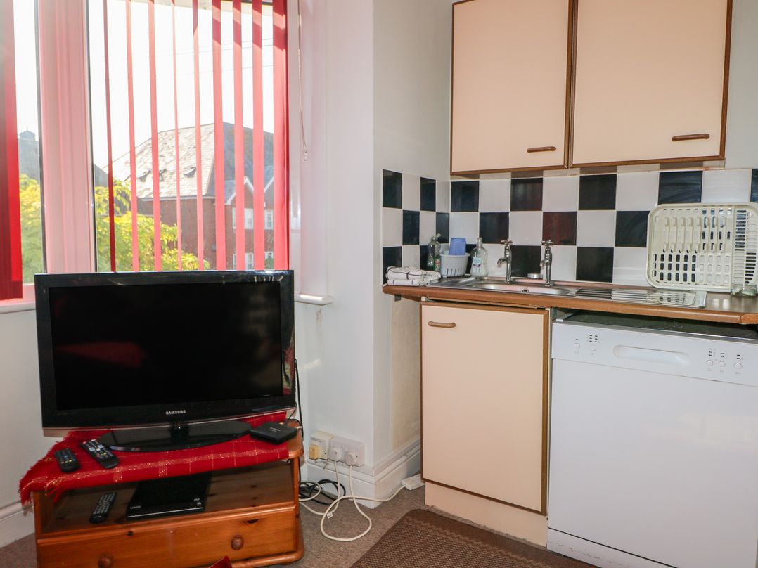A kitchen with a television and sink at Sylvian in Bexhill-On-Sea