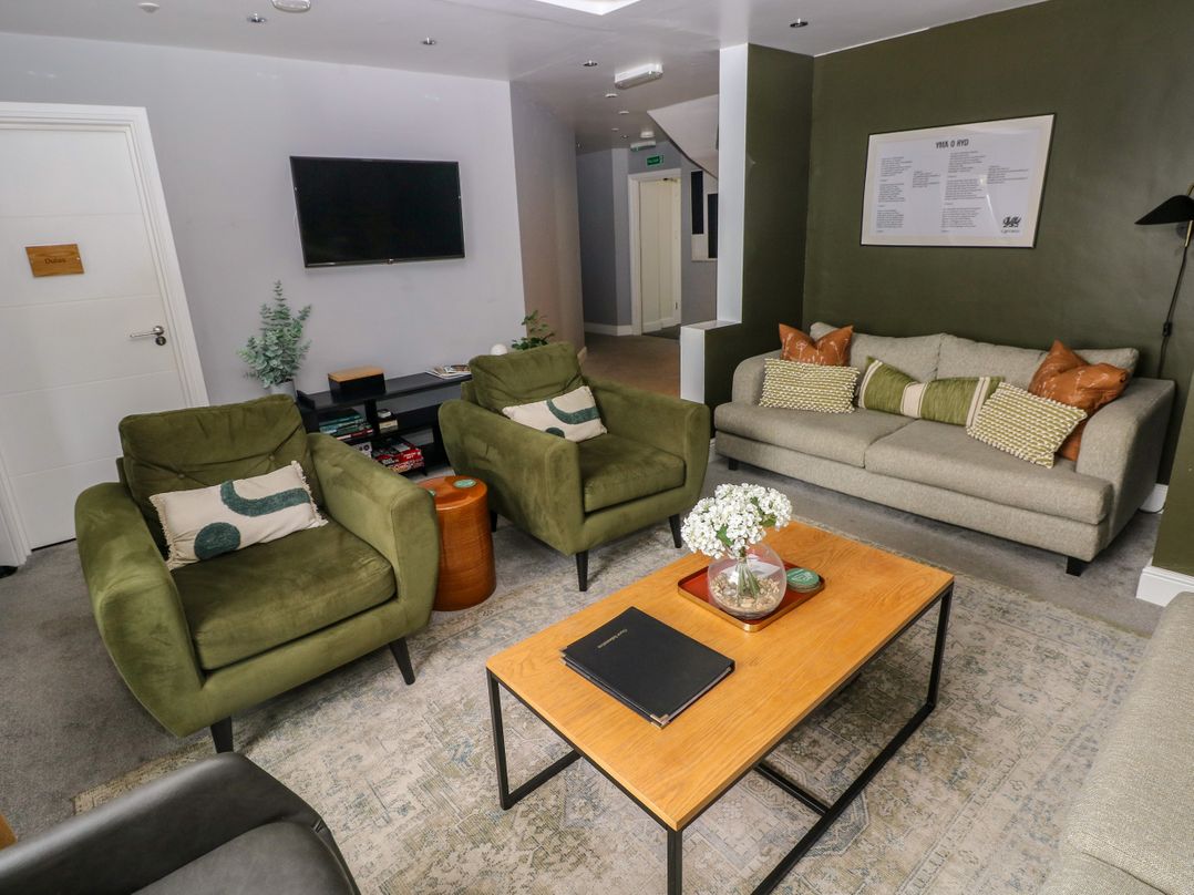 A living room with green furniture and a coffee table at Teifi Villa in St Dogmaels