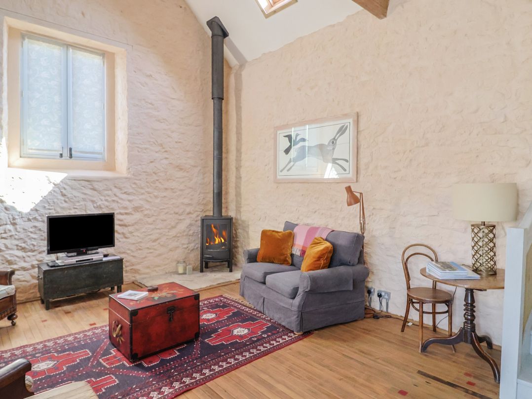 A living room with a sofa and television at The Stone Barn in Bridport