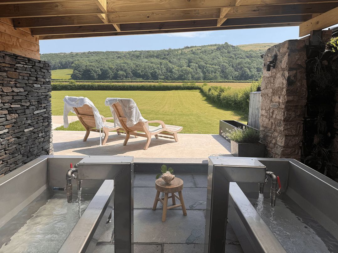 An outdoor area with tubs and chairs at Middle Longlands in Cartmel
