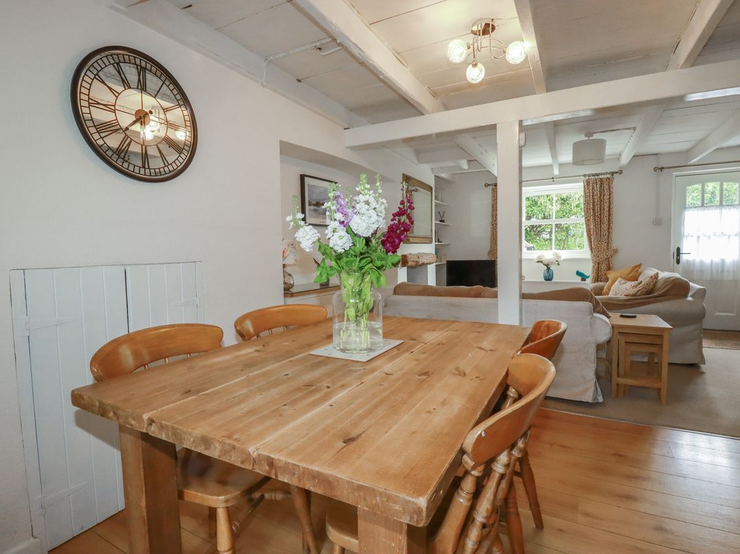 A dining room with a wooden table and chairs at Gwynn Cottage St Mabyn