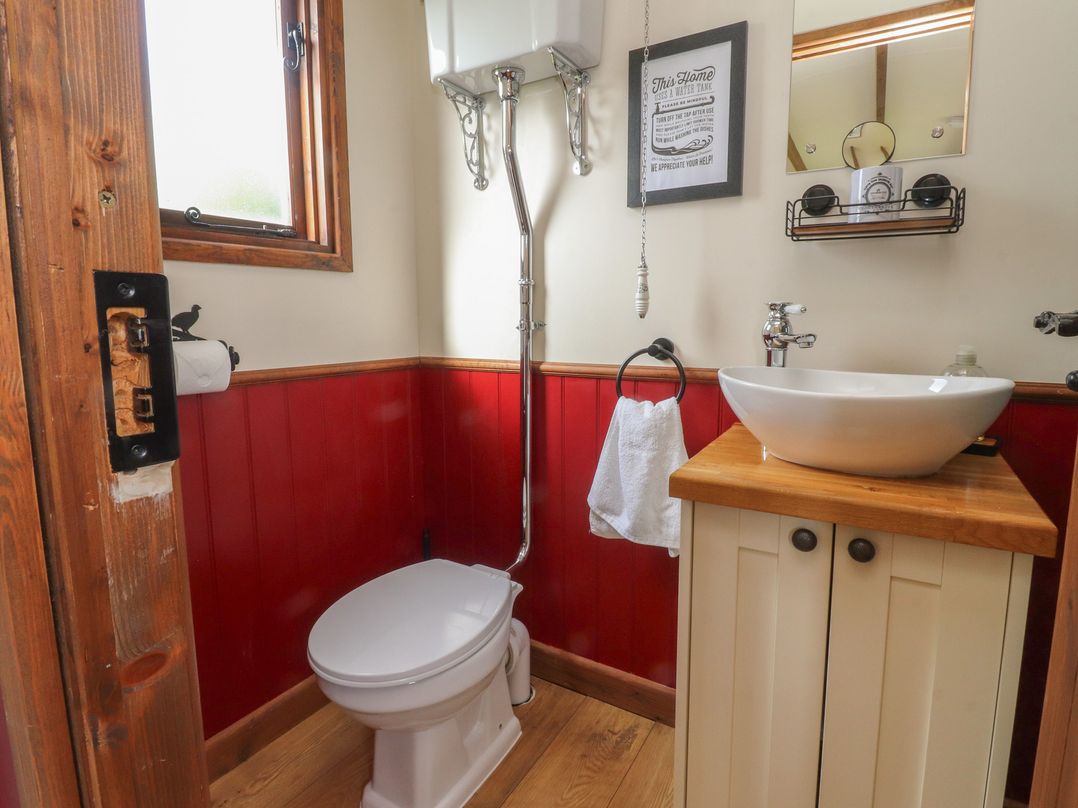 A bathroom with a toilet and sink at The Herdsman Luxury Shepherds Hut in Barnoldswick